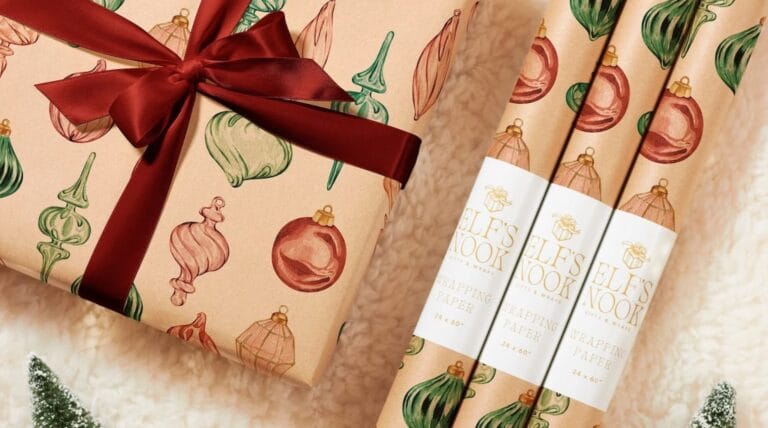 Eco friendly wrapping paper by Elf’s Nook featuring hand-drawn ornament illustrations and a reusable red ribbon