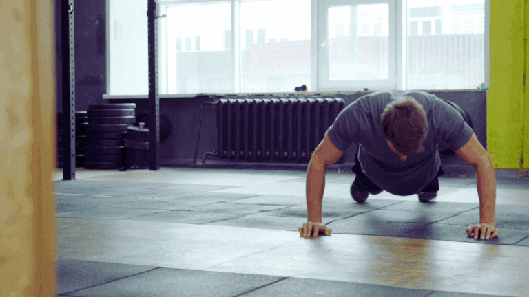 Guy in a gym struggling to a do a core workout