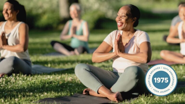 Image of women sitting in Easy Pose outside on grass, smiling.