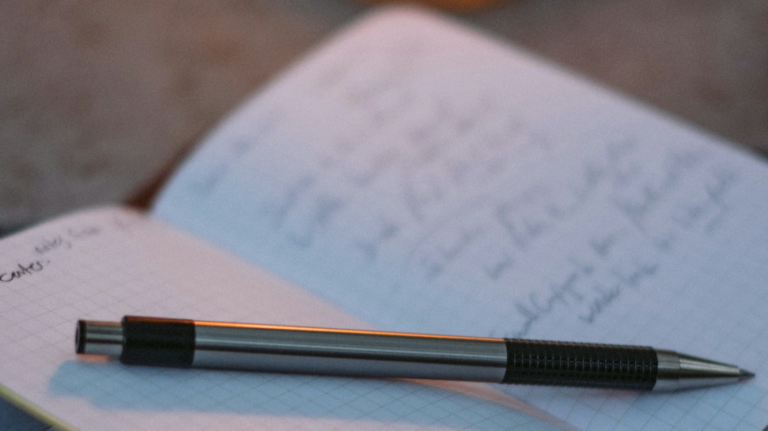 An open writing journal with a pen
