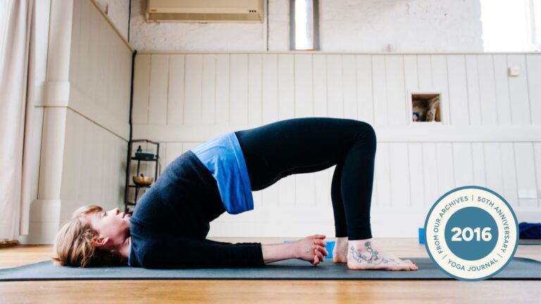 Woman in Bridge Pose on yoga mat.