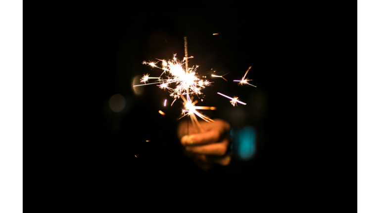 Woman holding a sparkler outside in the night sky