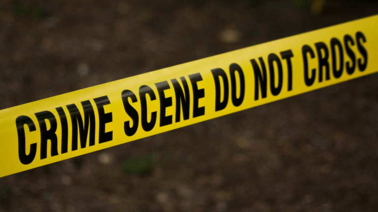 Bright yellow crime scene tape against a dark background as the setting for a murder mystery novel