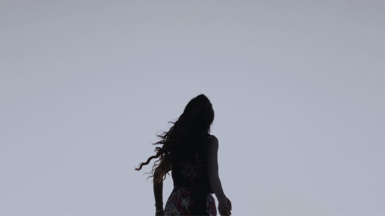 Silhouette of a woman outside during winter at dusk looking ahead and contemplating her weekly horoscope