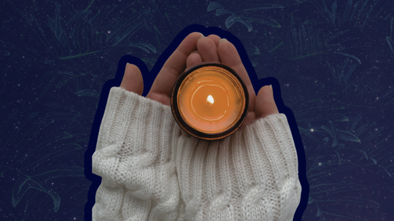 A person holding a candle against a night sky