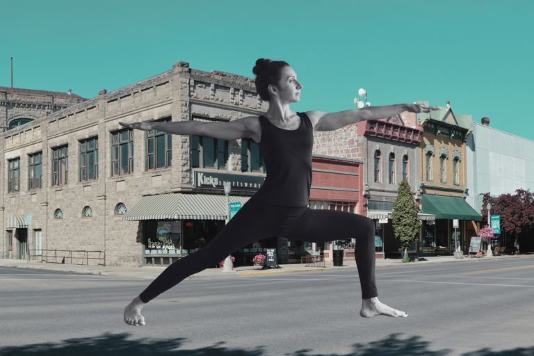 A woman practicing yoga in the streets of a small town