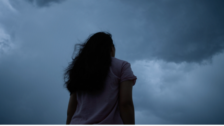 Woman standing outside beneath the new Moon in Capricorn thinking about her weekly horoscope