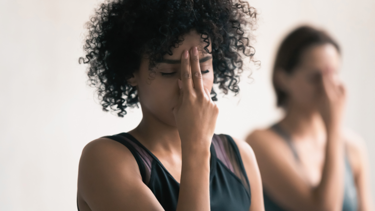 A woman demonstrating Alternate Nostril Breathing, part of her new moon yoga practice