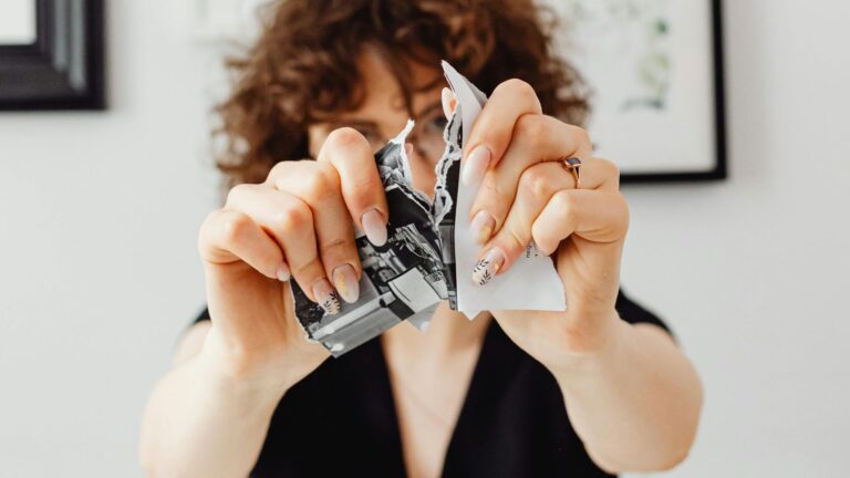 Image of woman ripping a piece of black and white paper.