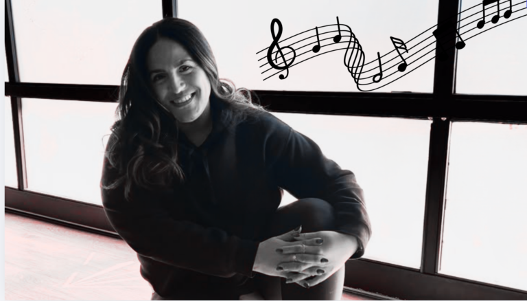 Yoga teacher Anaiz Ochoa sitting on the wood floor at Sweatshop Central yoga studio in Phoenix, where she teaches yoga with Bad Bunny playlists