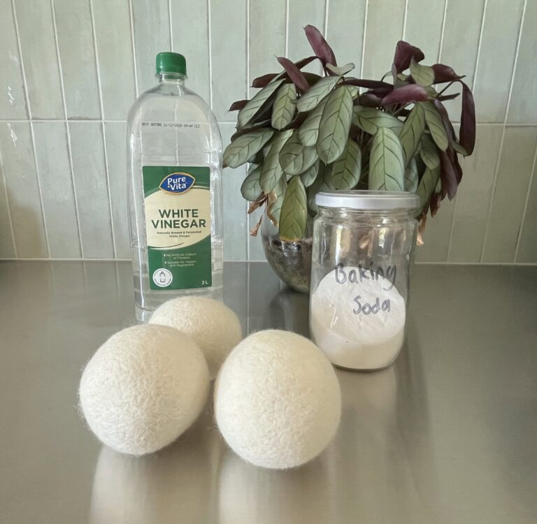 Sustainable Jungle's tested recommendations for natural fabric softener alternatives including white vinegar, wool dryer balls, and baking soda in a reusable glass jar on a kitchen counter