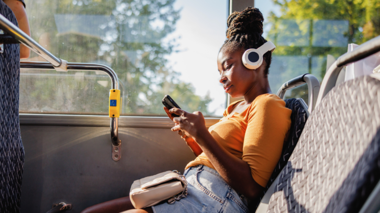 A woman using her phone on a bus