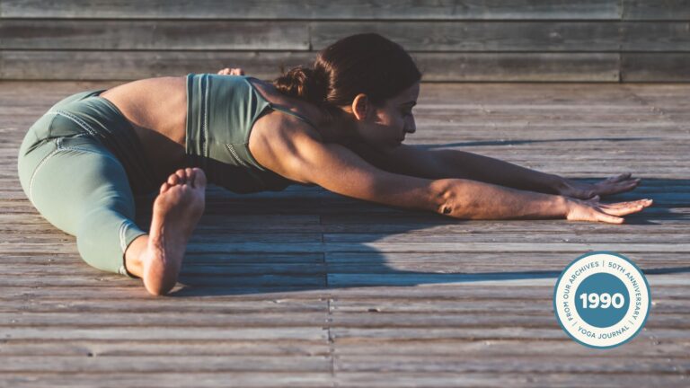 Woman practicing Seated Angle Pose outside.